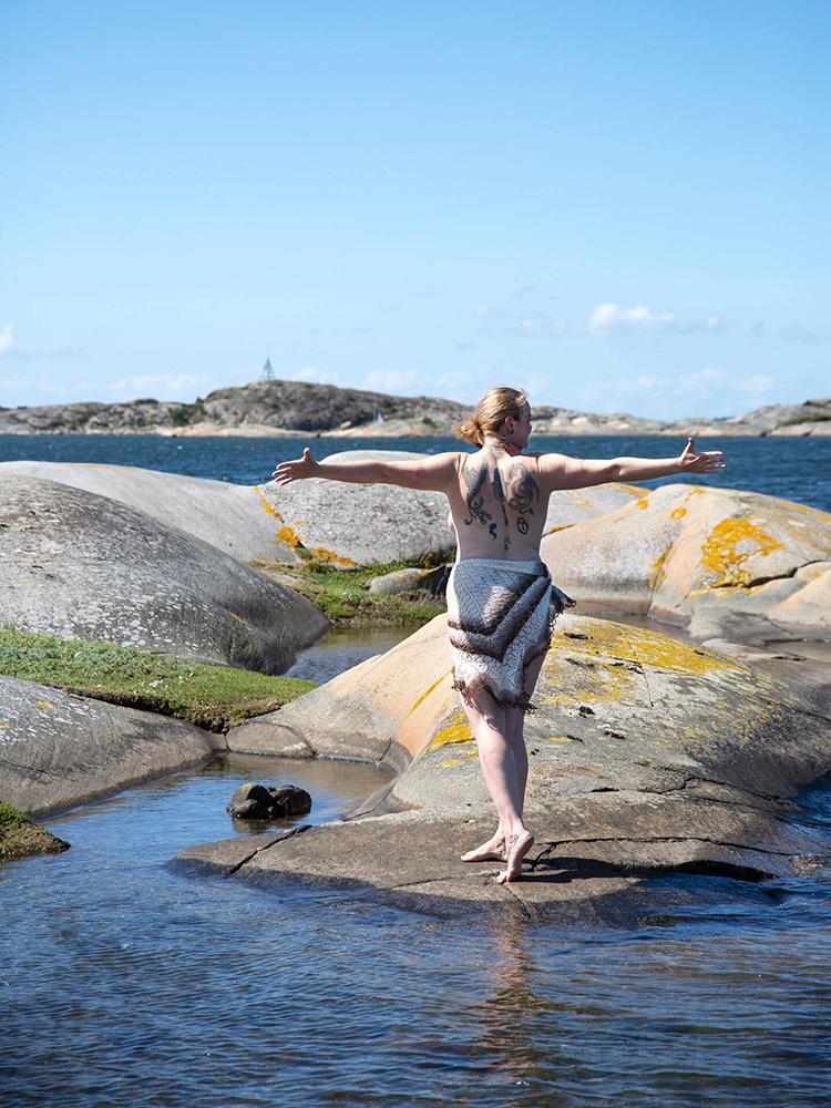 hav-kvinna-vagor-oppna-armar-blatt-portratt Kvinna på klippor vid havet med öppna armar i möte med havet.